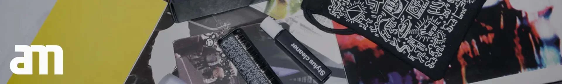 A collage of colourful images and objects featuring a black pouch with white abstract designs, a stylus cleaner, and a prominent yellow rectangle.
