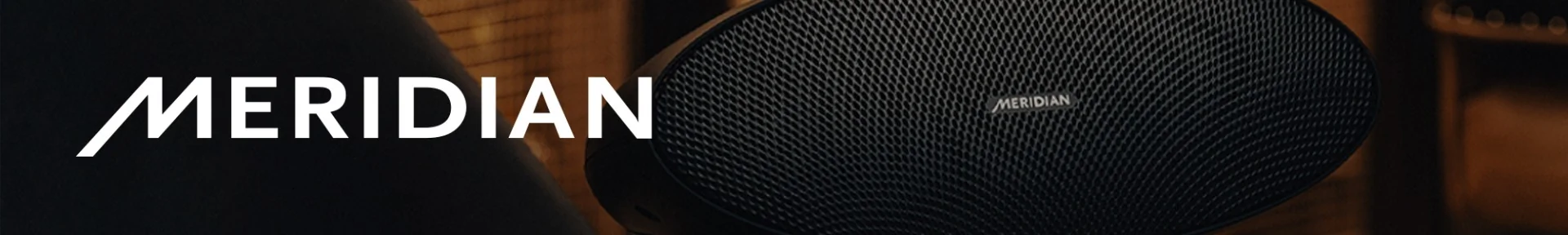 Close-up of a stylish Meridian speaker with intricate mesh design, set against a warm, softly lit background. The word 'MERIDIAN' is boldly displayed in white.
