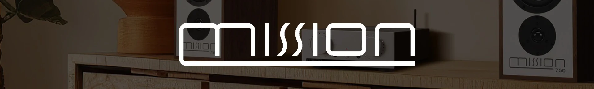Stylish interior with a modern audio setup; two speakers labelled "mission" frame a sleek console on a wooden shelf, evoking a cosy, tech-savvy ambiance.