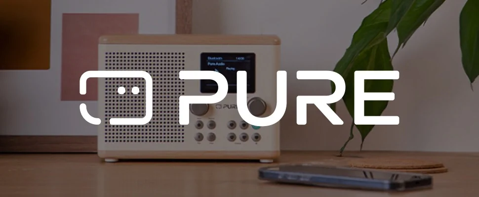 A white radio with a digital display reading "Bluetooth, Pure Audio." It features control knobs. To the right is the logo "PURE" near a plant, creating a calm vibe.