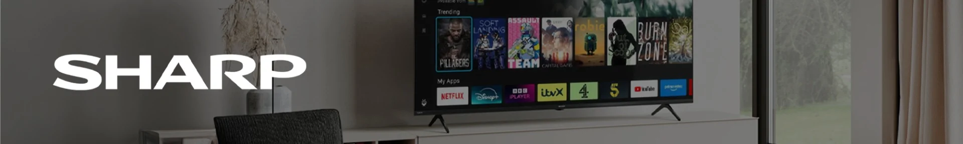 Modern living room with a large Sharp TV displaying various streaming apps like Netflix and YouTube. Bright and sleek ambiance.
