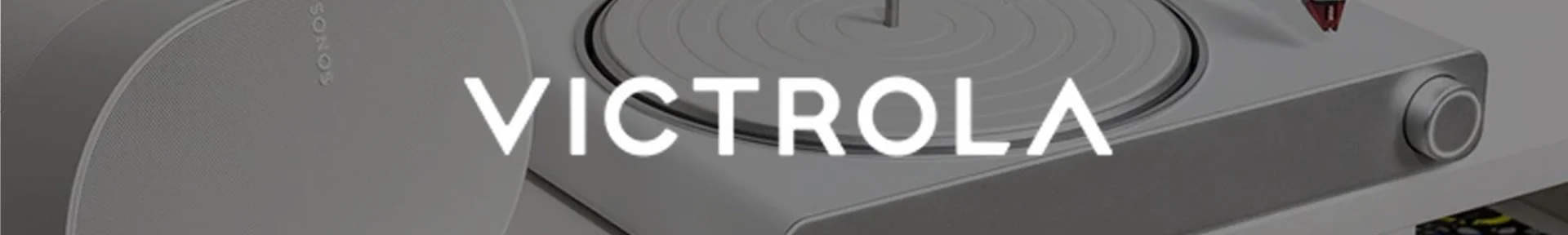 Close-up of a modern grey turntable with a sleek design, featuring the brand name 'Victrola' in bold white text across the centre.