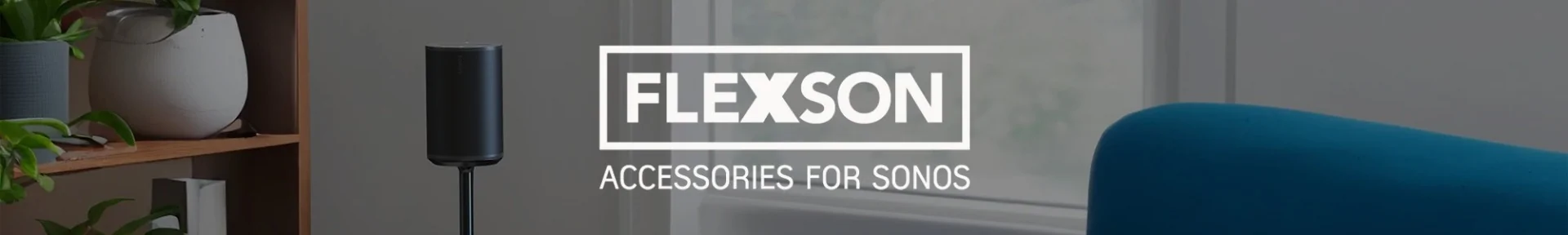 Cosy living room with a sleek black speaker on a stand, wooden shelf with plants, and modern décor. Text reads, “Flexson Accessories for Sonos.”
