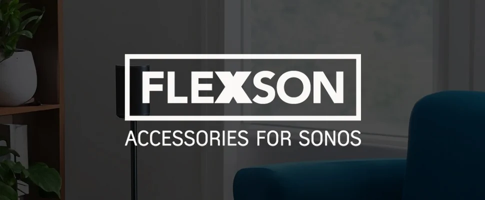 Cosy living room with a sleek black speaker on a stand, wooden shelf with plants, and modern décor. Text reads, “Flexson Accessories for Sonos.”