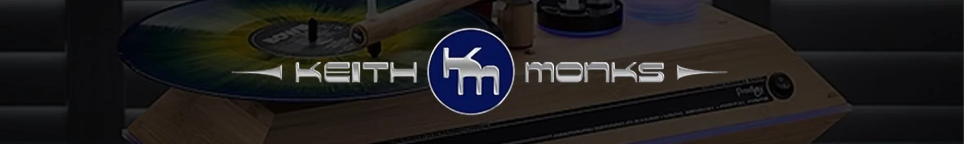 A vinyl record is spinning on a wooden turntable, partially visible with the logo 'Keith Monks' in metallic font overlaying the image.