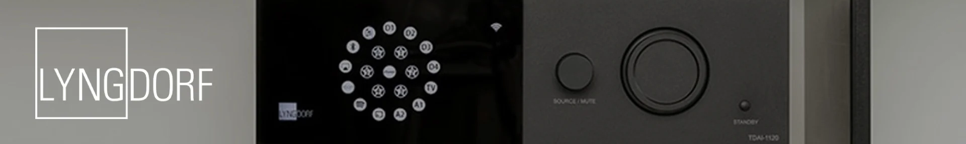 Close-up of a sleek audio device featuring a circular button layout on a black panel. The word "Lyngdorf" appears on the left. Modern and minimalistic design.