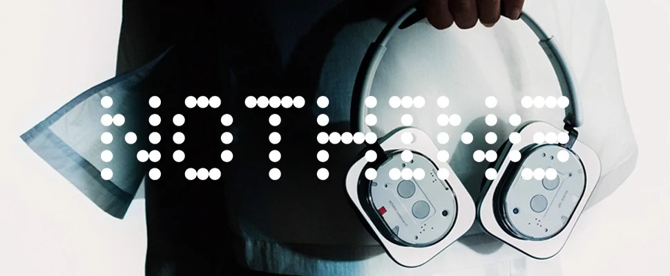 Monochrome image with the word "NOTHING" in Braille on the left and a geometric design resembling headphones or audio devices on the right. Minimalist and abstract.