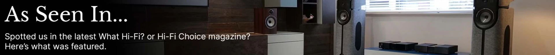 Living room featuring large speakers, modern d&eacute;cor, and a coffee table. Overlay text reads, "As Seen In... What Hi-Fi? or Hi-Fi Choice magazine?"