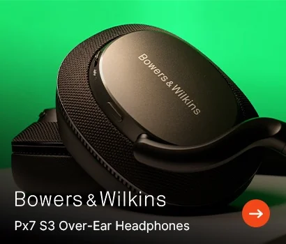 Close-up of Bowers & Wilkins Px7 S3 over-ear headphones on a green background. The sleek black design conveys a modern, high-quality audio experience.