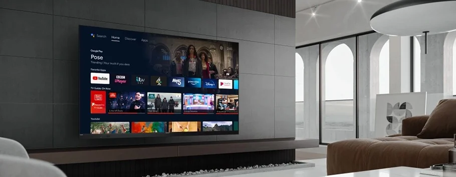 Sleek living room with a large flat-screen TV displaying streaming apps and shows. Modern sofa and arched windows create a stylish, serene atmosphere.
