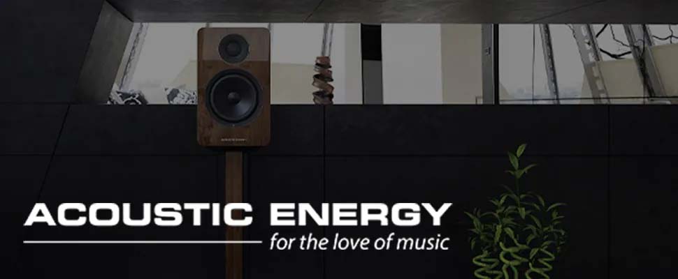 A sleek, modern speaker stands beside a plant against a dark wall. Above, the text "Acoustic Energy for the love of music" suggests high-quality audio.