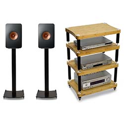 Two sleek black speakers with orange cones on stands beside a wooden audio rack with four shelves holding electronic components, conveying a modern audio setup.