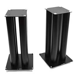 Two black, metal speaker stands with square bases and tops. Each stand has four vertical cylindrical columns, conveying a sleek, modern design.