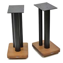 Two black metal speaker stands with square bases made of light wood are shown against a white background, combining modern and natural elements.