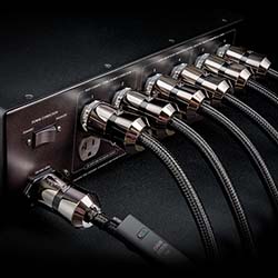 A sleek, black audio equipment back panel with six high-quality cables connected, conveying a sense of precision and professional functionality.