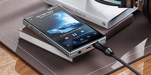 Smartphone playing music on a stack of books, with headphones nearby. The scene conveys a relaxed, modern vibe with a focus on technology and leisure.