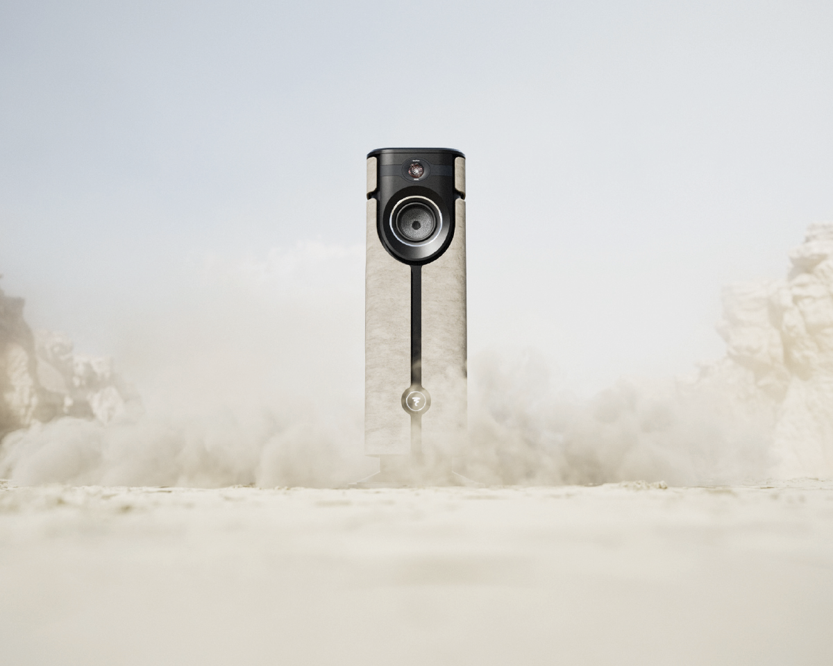A sleek, cylindrical camera-like device stands upright in a dusty, desert-like landscape. Dust swirls at its base, creating a dynamic and mysterious atmosphere.