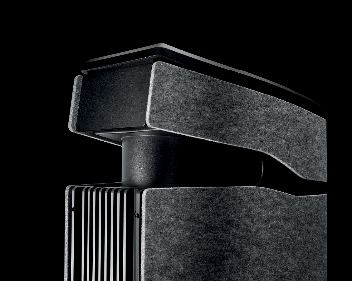 A sleek, modern air purifier with a black and gray exterior, featuring layered, textured panels and a minimalist design on a black background.