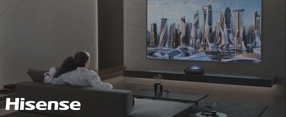 Two people sit on a couch in a dimly lit living room, watching a futuristic cityscape on a large Hisense TV. The scene is calm and immersive.