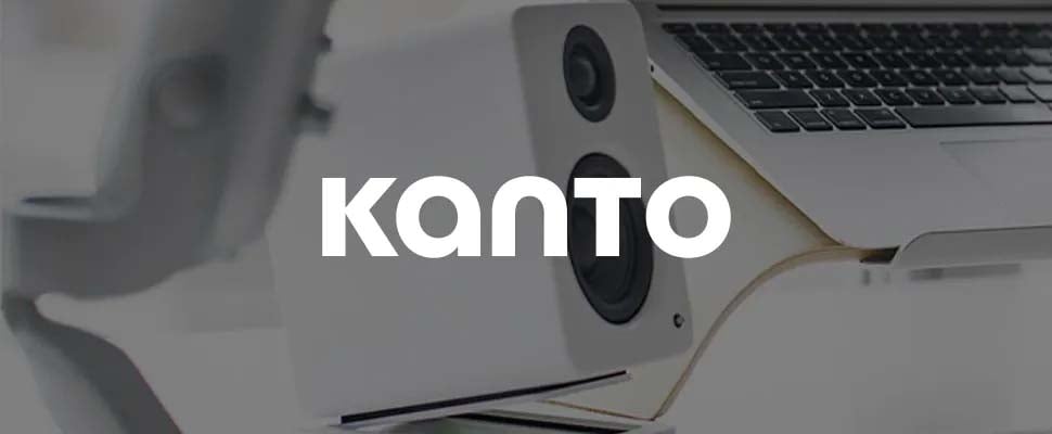 Modern desk setup with a sleek white speaker and a laptop, creating a minimalist and tech-savvy atmosphere. Bold "Kanto" text overlays the image.