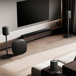 A modern living room with a sleek home theater system, including a wall-mounted TV, speakers, and subwoofer, creating a minimalist and sophisticated ambiance.