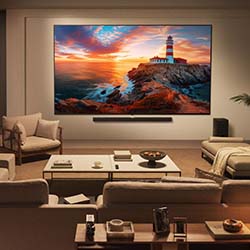 A cozy, modern living room with a large TV on the wall displaying a sunset over a lighthouse. Neutral-toned furniture surrounds a sleek coffee table.