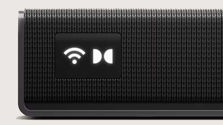 Close-up of a black, textured soundbar featuring illuminated icons for Wi-Fi and Dolby Audio, suggesting advanced connectivity and audio technology.