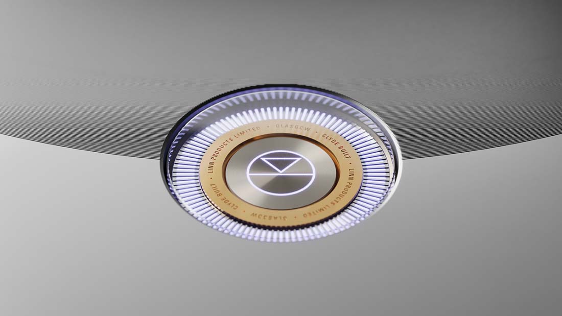 A circular, futuristic ceiling light with a glowing ring and geometric design, set against a minimalistic gray background. The light exudes a sleek, modern tone.