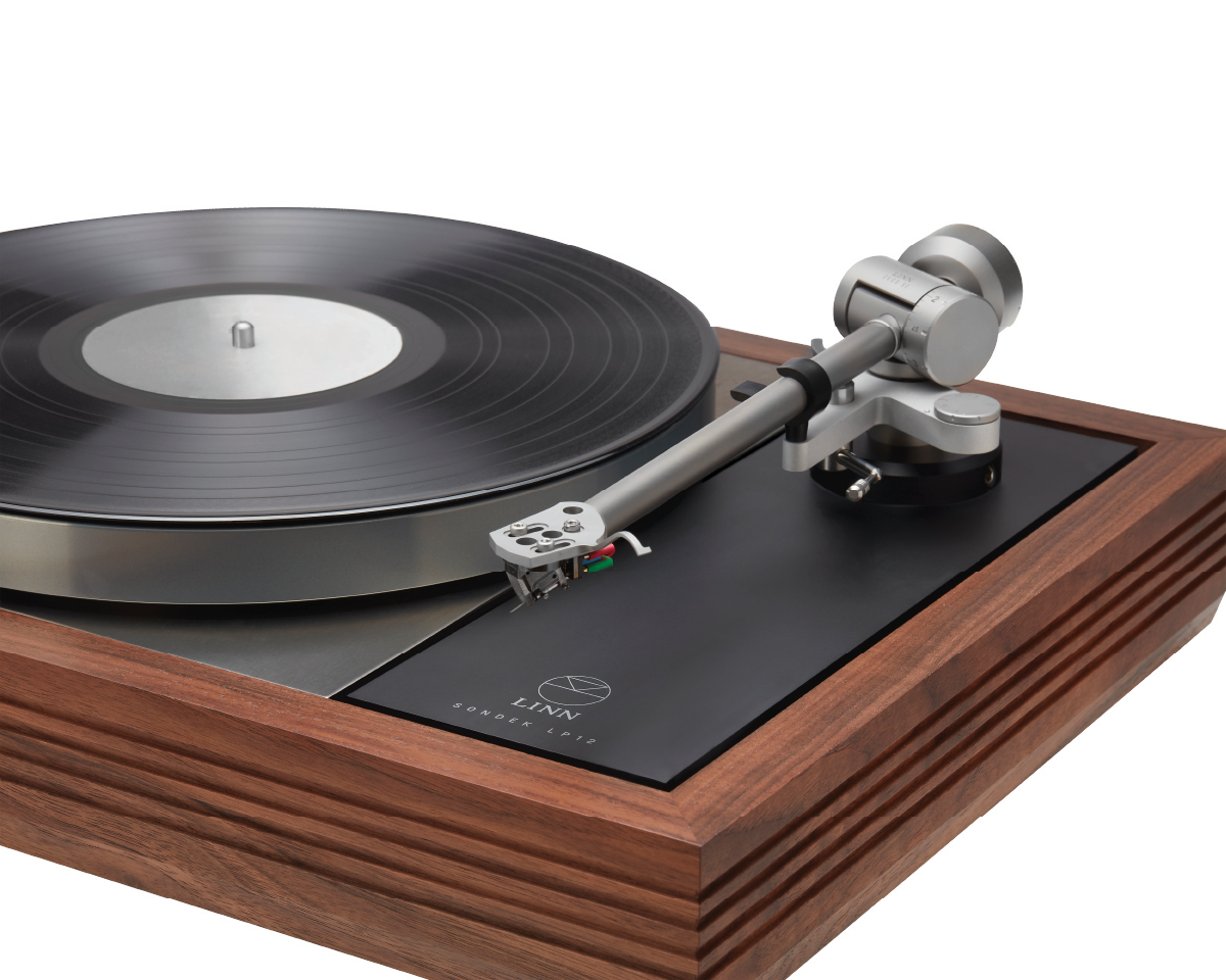 A high-end turntable with a sleek design features a vinyl record on a spinning platter. It has a wooden frame and modern tonearm, conveying elegance and sophistication.