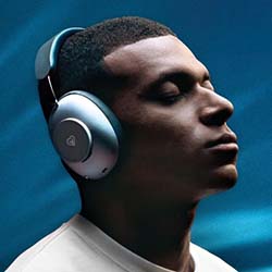 A person with closed eyes, wearing sleek over-ear headphones, appears relaxed against a blue background. The mood is serene and contemplative.
