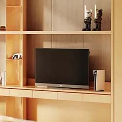 Modern living room setup with a TV on a wooden shelf, flanked by a gaming console to the right and two decorative figures above, creating a cozy ambiance.
