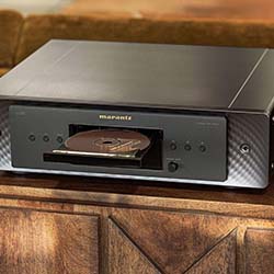 A sleek black CD player displaying an open CD tray with a disc inserted, set on a wooden cabinet, creating a nostalgic, vintage atmosphere.