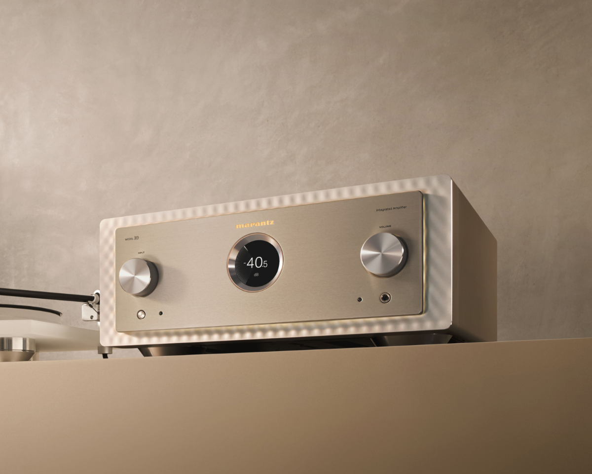 A sleek, modern audio amplifier with a brushed metal finish, two large control knobs, and a digital display reading "-40.5," set against a neutral wall.