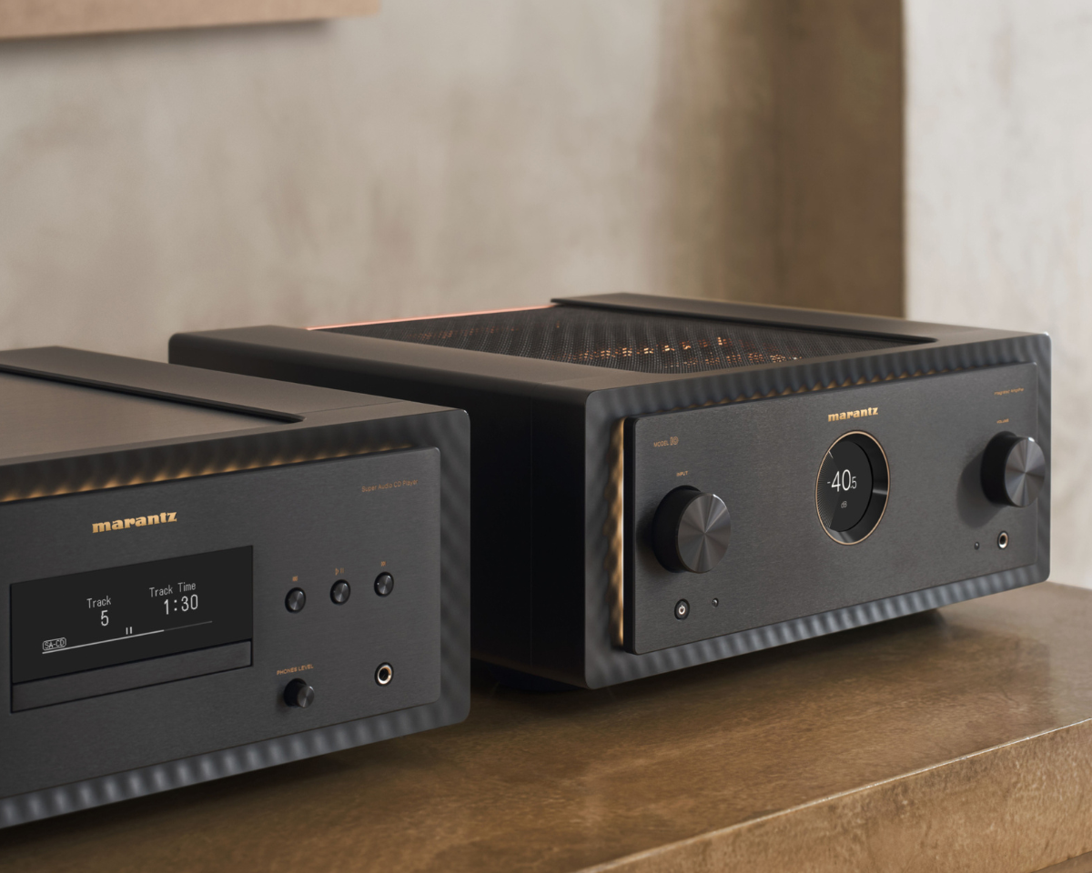 Two sleek, modern Marantz audio components on a wooden surface. The left unit shows track details, and the right unit features a central volume knob.