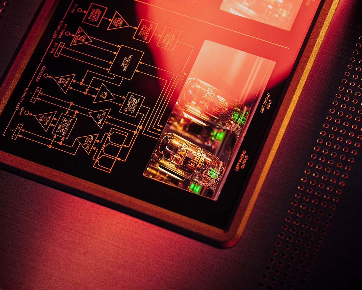 Close-up of a circuit board with glowing vacuum tubes, illuminated by warm red and orange light. The scene conveys a futuristic, high-tech ambiance.