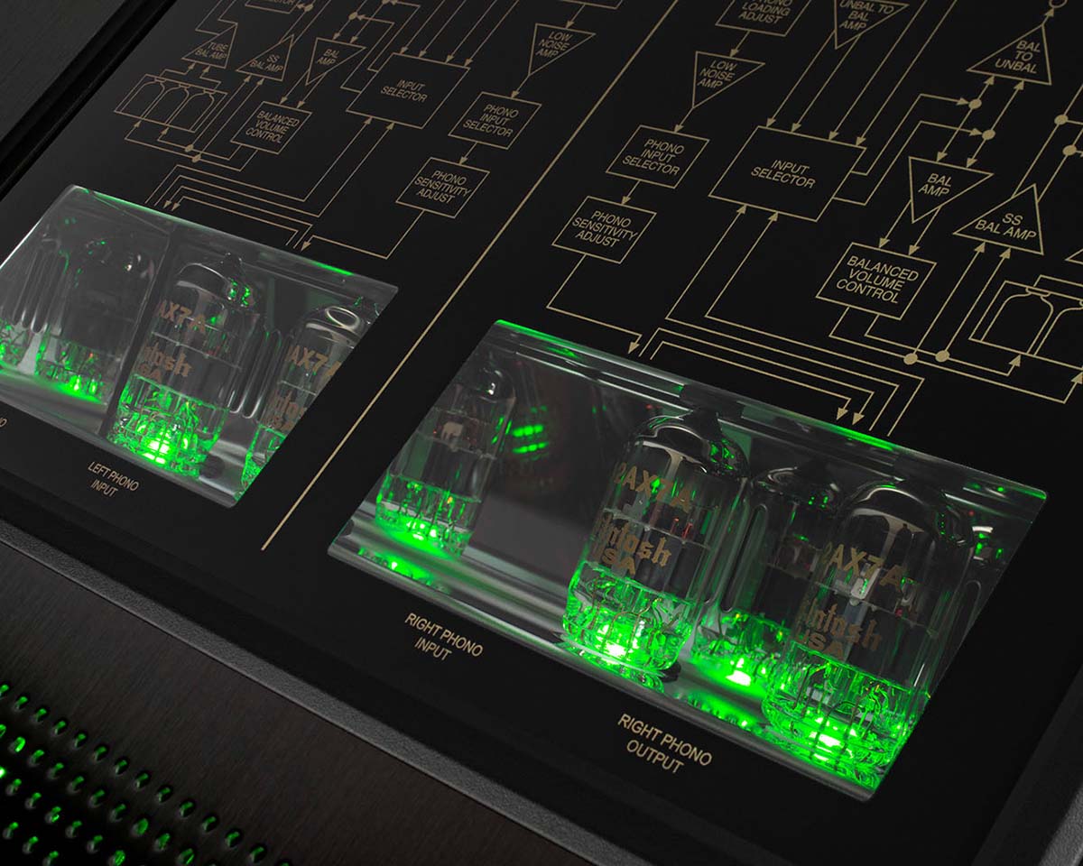 Close-up of a modern audio amplifier showcasing glowing green vacuum tubes. Gold circuit diagrams are visible above, creating a high-tech ambiance.