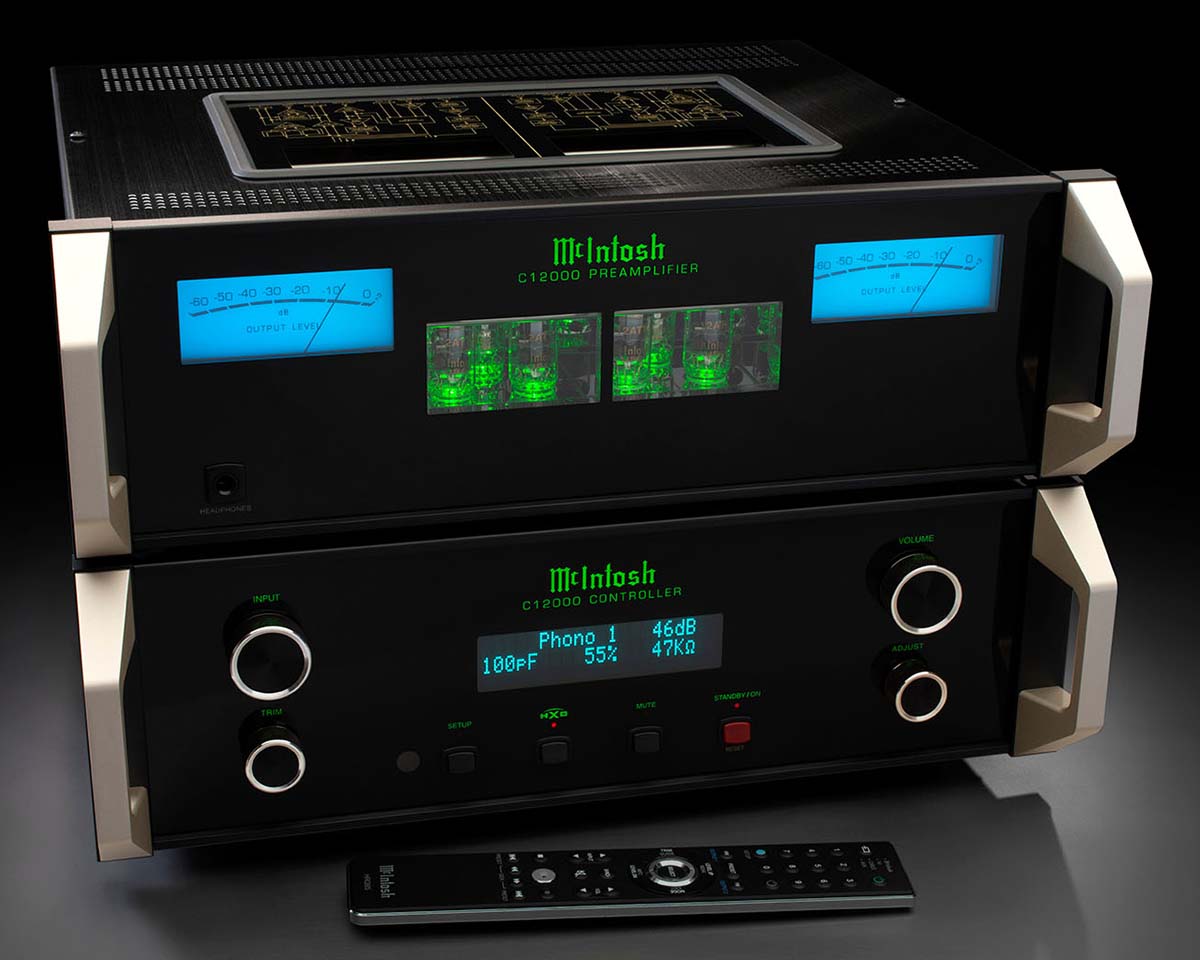 High-end McIntosh audio equipment with illuminated displays, sleek black design, and control knobs. Remote control included, set on a dark surface.