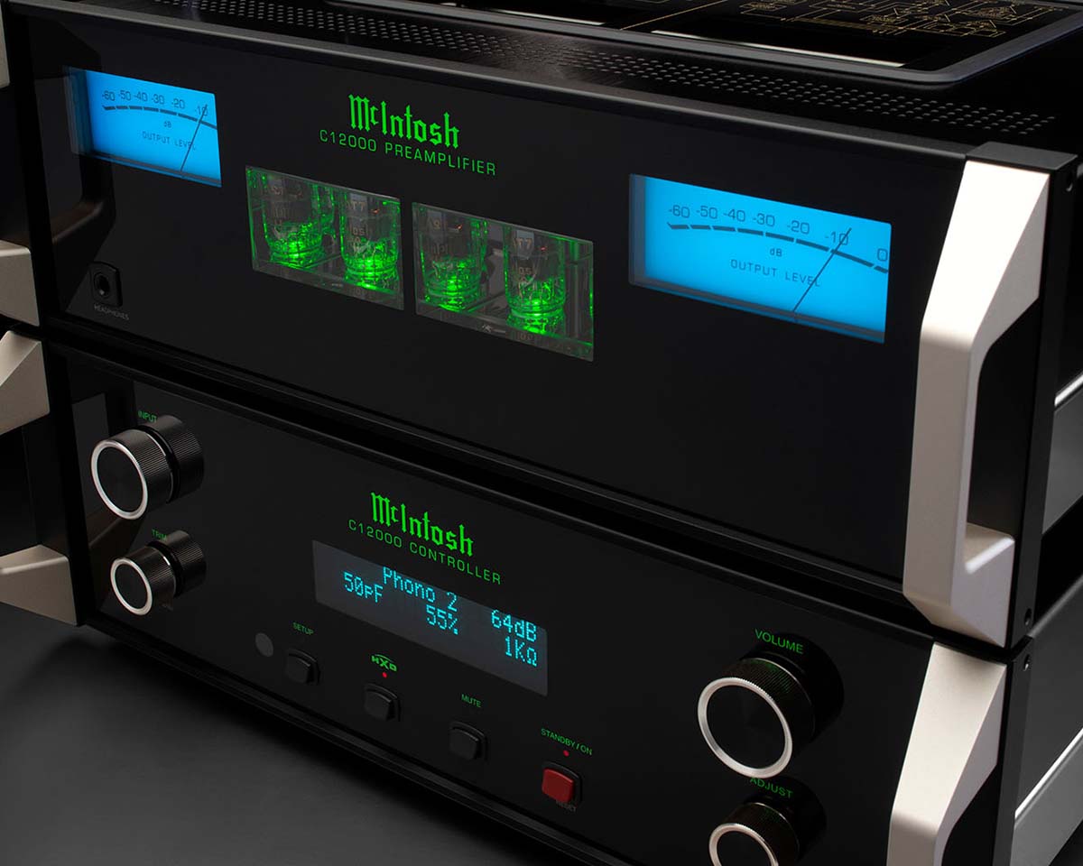 Close-up of McIntosh audio equipment with glowing green and blue displays, silver knobs, and a sleek black exterior, conveying a high-end, modern feel.
