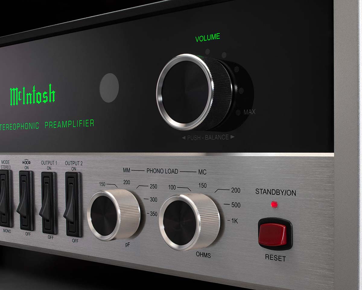 Close-up of a McIntosh stereophonic preamplifier showing the volume and balance knobs, switches, and a red standby button, exuding a sleek, modern feel.