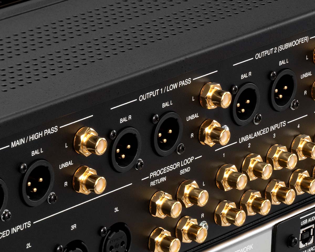 Close-up of a black audio interface showing various gold-plated inputs and outputs. Labels include "Main/High Pass" and "Unbalanced Inputs." It exudes a professional, high-quality vibe.