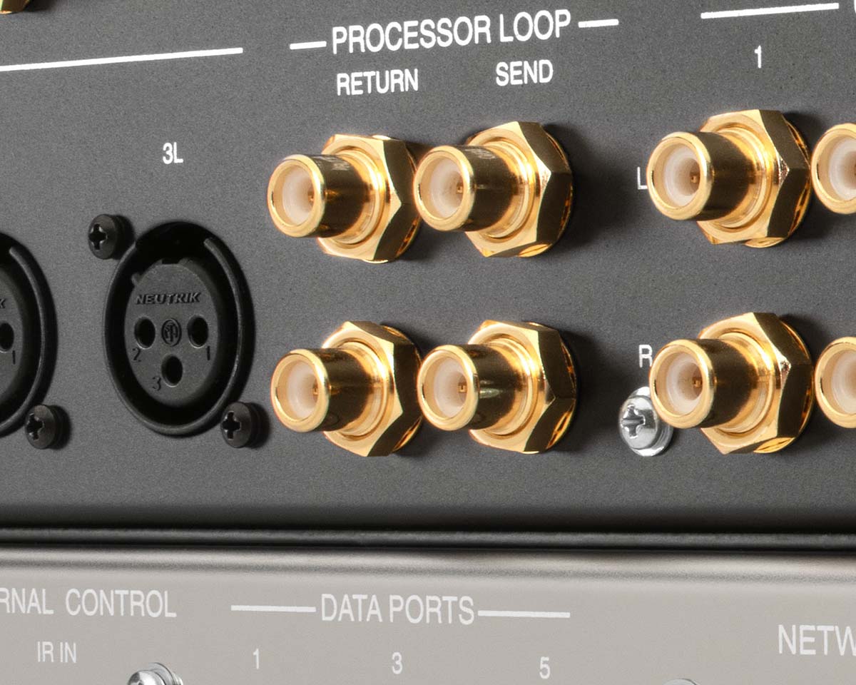 Close-up of a device panel with multiple gold-plated connectors labeled "Processor Loop." Circular black ports are on the left, creating a sleek, technical look.
