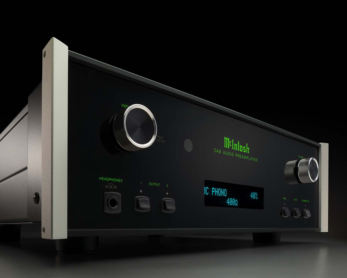 A sleek black McIntosh audio preamplifier with silver knobs and a glowing green display, set against a dark background, conveying a high-tech elegance.