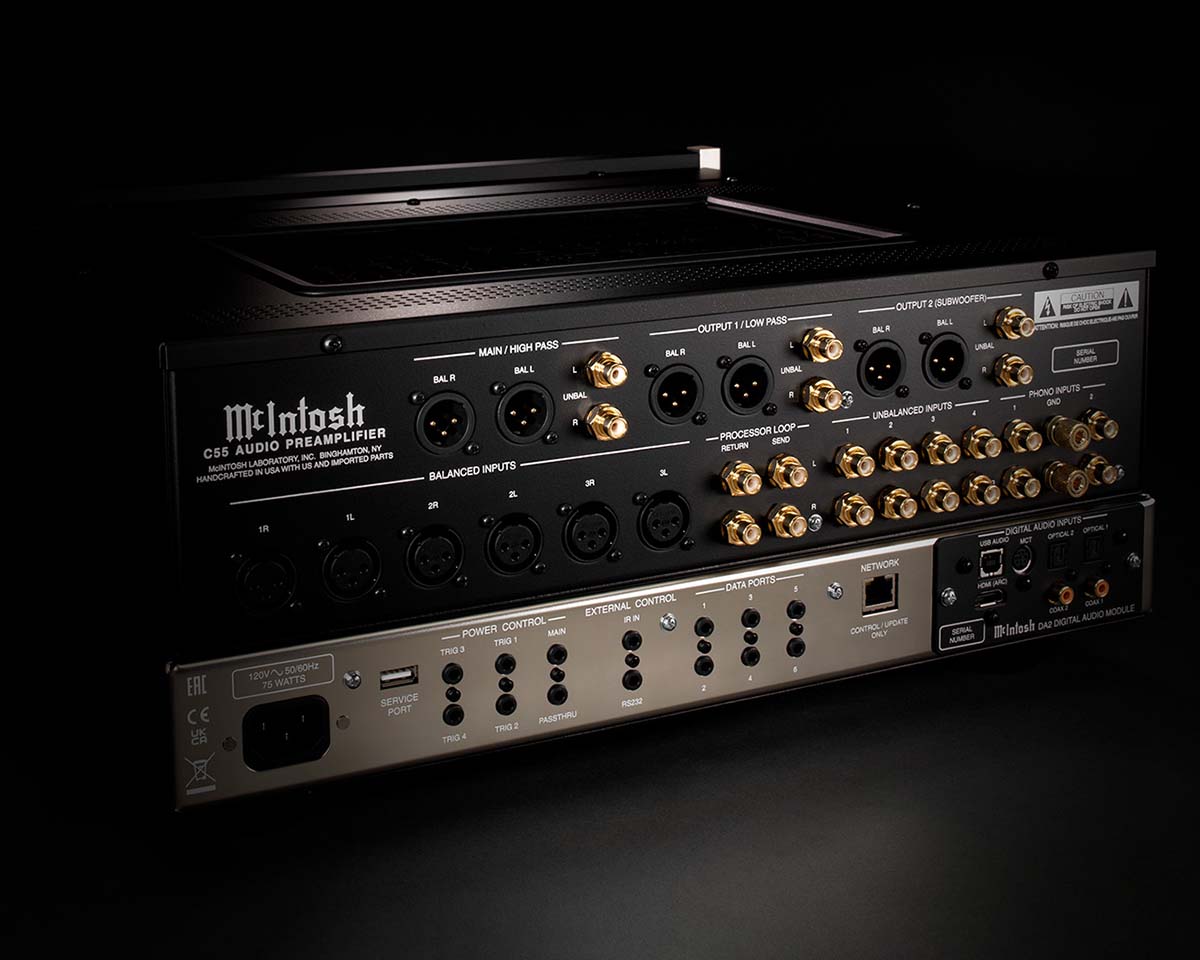 Back view of a McIntosh C53 audio preamplifier on a dark background, featuring multiple gold-plated connection ports and black balanced inputs.