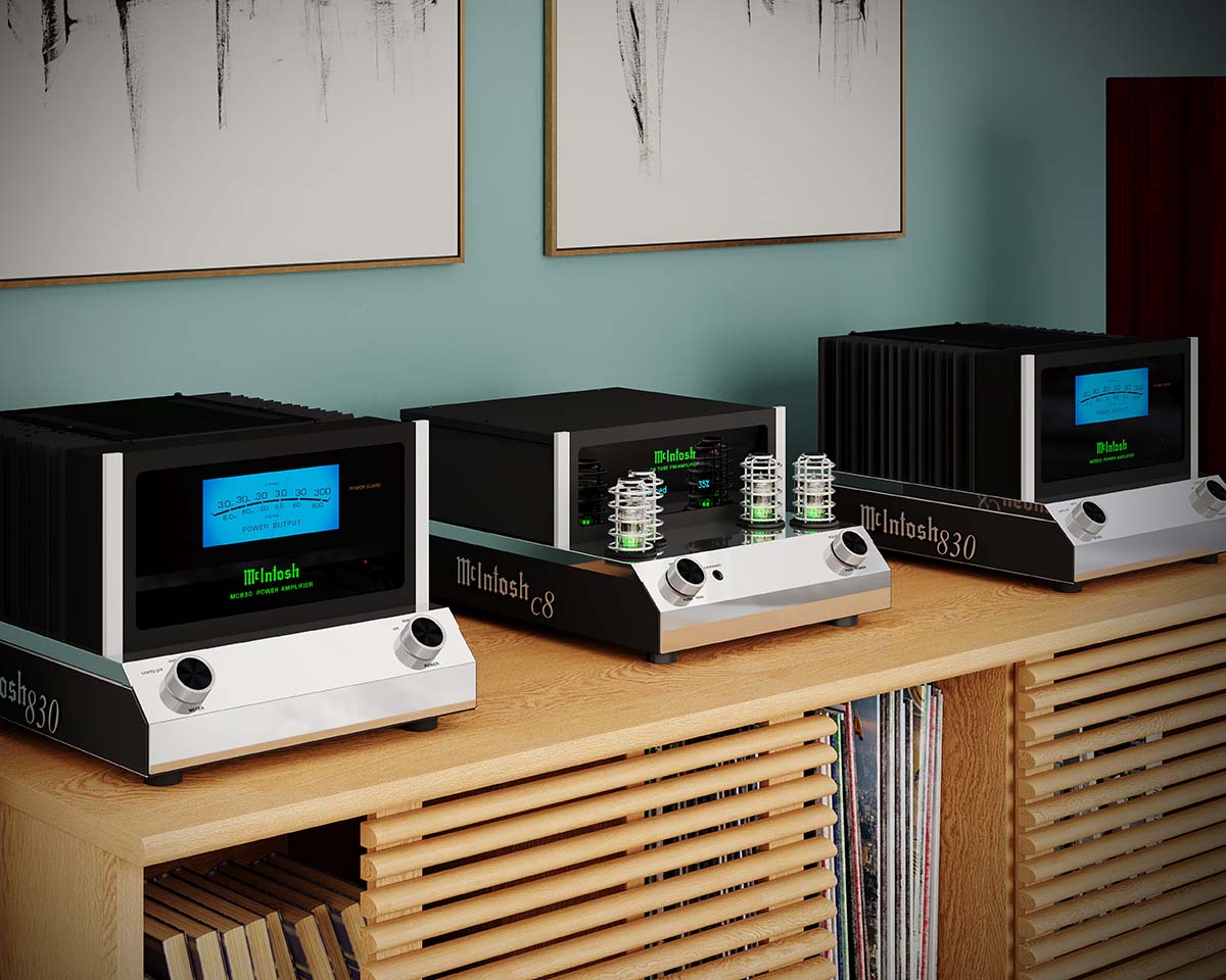 Three McIntosh amplifiers on a wooden shelf under framed abstract art. The room has a sophisticated, vintage audio vibe with a teal wall.