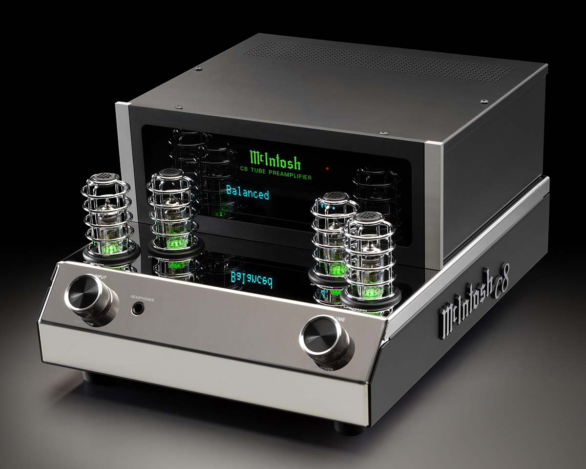 A sleek McIntosh tube preamplifier with chrome accents and glowing green lights on a reflective surface. Modern, high-end audio equipment with vintage flair.