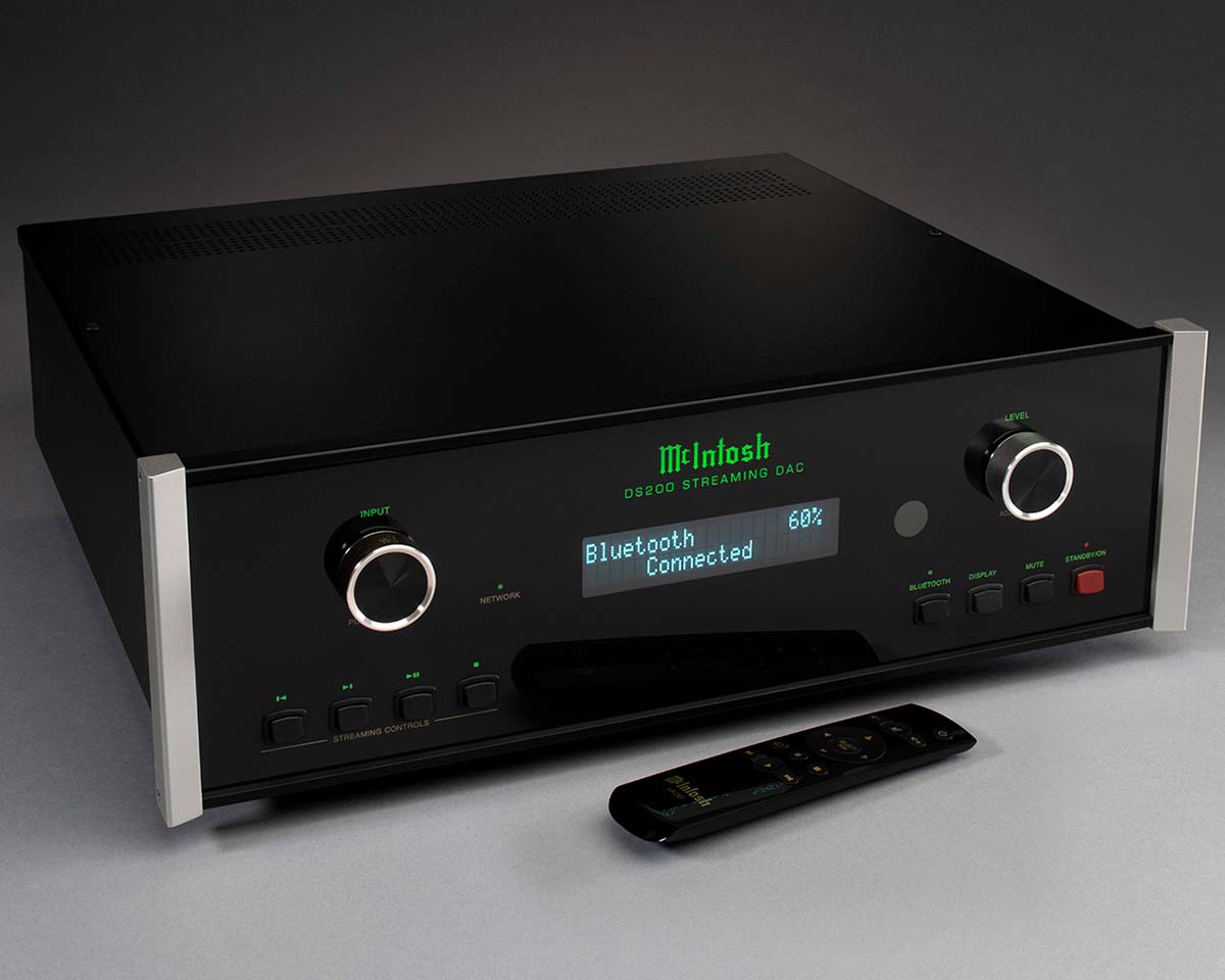 Sleek black audio equipment with a digital display reading "Bluetooth Connected 60%". Features knobs, buttons, and a remote on a gray background.