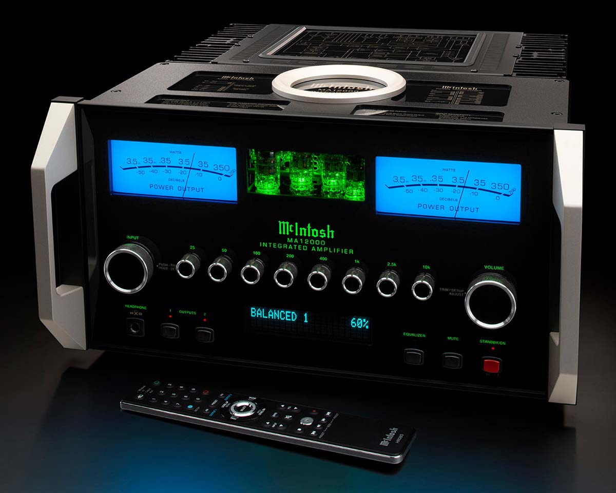 High-end McIntosh amplifier with glowing blue meters and green-lit tubes on a black background. Buttons and dials create a modern, techy vibe. Remote control in front.