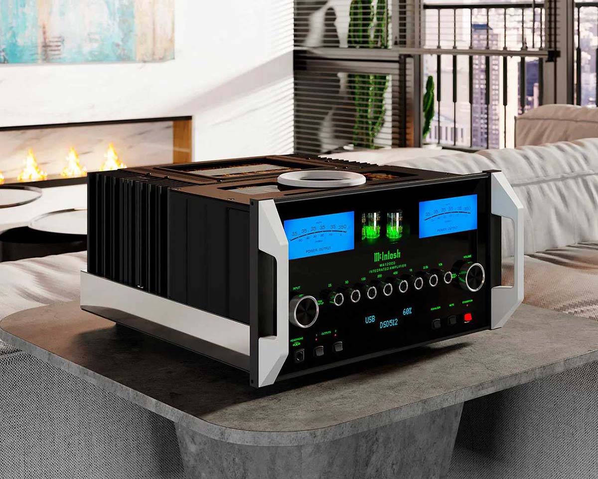 A sleek black and silver audio amplifier with glowing blue and green meters sits on a table in a modern living room. A fireplace burns in the background.