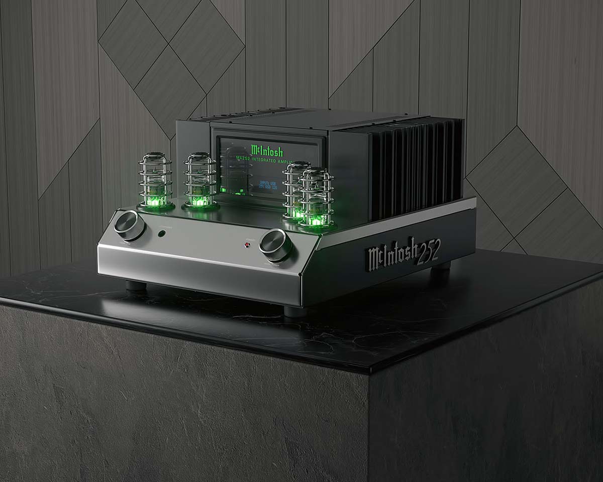 High-end audio amplifier with glowing green tubes and a sleek metallic finish on a dark marble surface. The setting is modern and sophisticated.