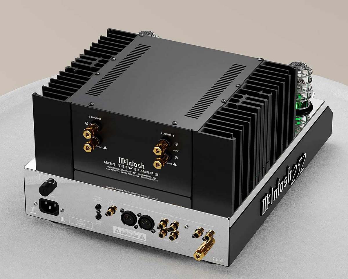 Vintage-style integrated amplifier with black cooling fins and various gold-plated connectors. The green glowing tubes add a modern, sophisticated touch.